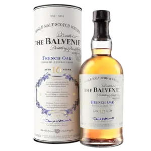 בקבוק של The Balvenie French Oak 16 Year Old Single Malt Scotch Whisky עומד ליד הקופסה הגלילית התואמת שלו, שניהם מציגים הדגשות כחול וזהב עם טקסט ומיתוג מפורטים.