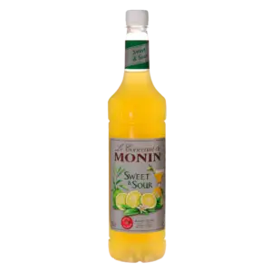 בקבוק של מונין סאוור מיקס SWEET & SOUR עם תווית ירוקה ולבן מציגה לימונים וליים; הנוזל בפנים הוא צהוב בהיר.