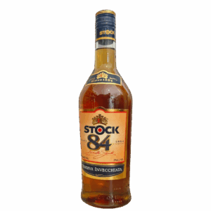 בקבוק קוניאק שטוק 84 עם תווית זהב ושמנת, פקק זהב ונוזל ענברי, שם המותג וסמל על רקע לבן. מתאים לאירועים – Alcohol Market. – אלכוהול מרקט