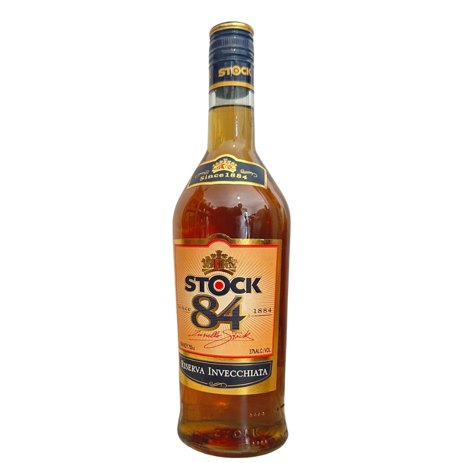 בקבוק קוניאק שטוק 84 עם תווית זהב ושמנת, פקק זהב ונוזל ענברי, שם המותג וסמל על רקע לבן. מתאים לאירועים – Alcohol Market. – אלכוהול מרקט